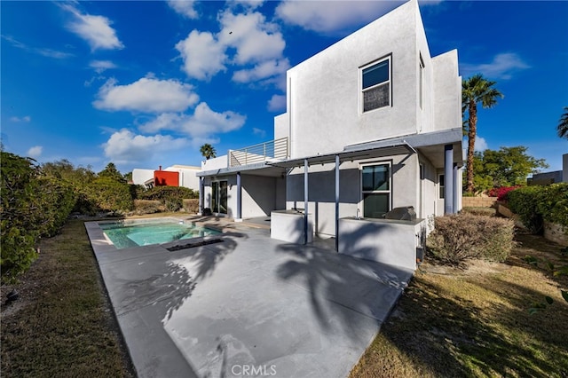 back of house featuring a patio and a balcony