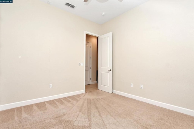 carpeted spare room featuring ceiling fan