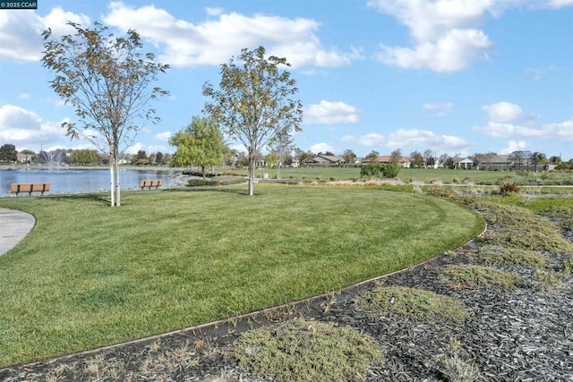 surrounding community featuring a water view and a lawn