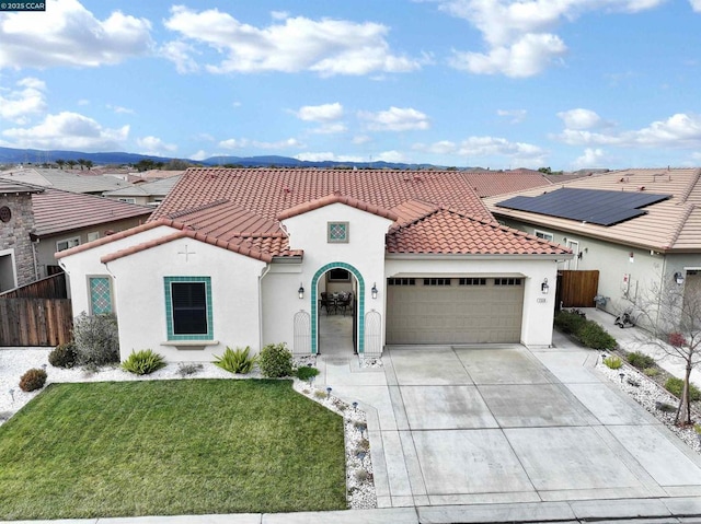 mediterranean / spanish house with a garage and a front lawn