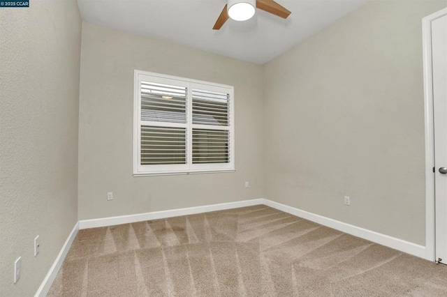 carpeted spare room featuring ceiling fan