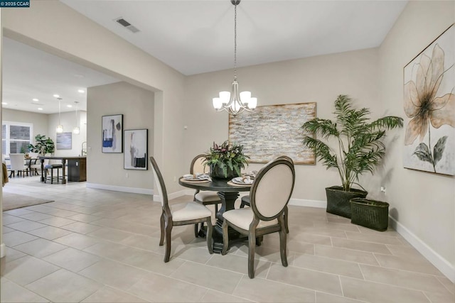 dining room with light tile patterned floors and a chandelier