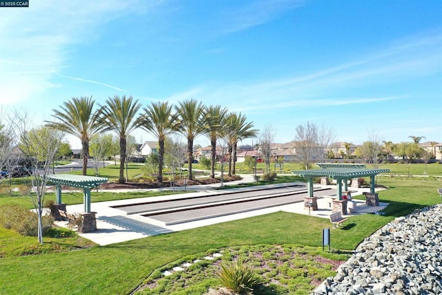 view of property's community featuring a pergola and a lawn