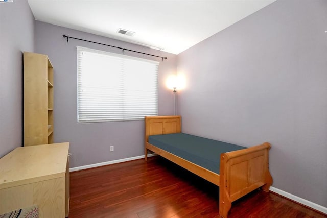 bedroom with dark hardwood / wood-style flooring