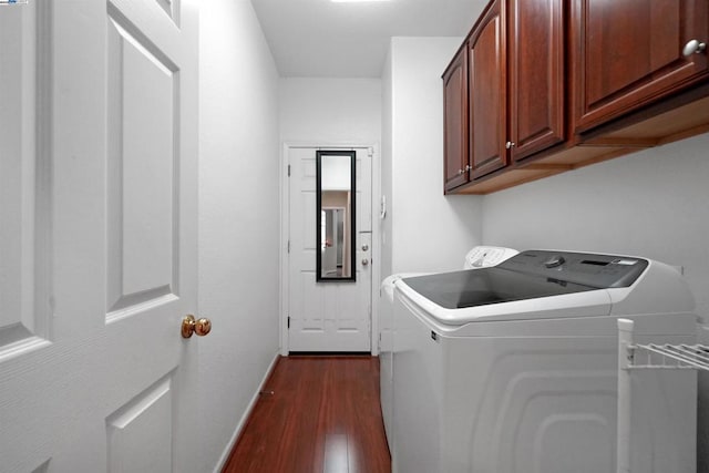 washroom featuring cabinets, dark hardwood / wood-style floors, and washing machine and clothes dryer