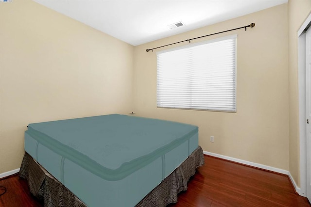 bedroom with dark hardwood / wood-style flooring