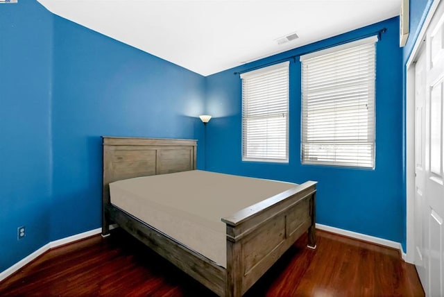 bedroom with dark wood-type flooring and a closet