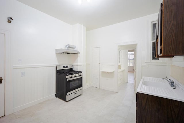 kitchen featuring dark brown cabinetry, sink, and stainless steel gas range oven