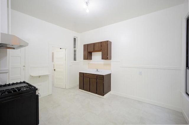 kitchen with ventilation hood, sink, black range with gas stovetop, and dark brown cabinetry