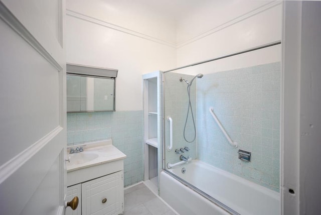 bathroom with tile walls, vanity, tile patterned flooring, and tiled shower / bath