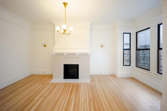 unfurnished living room with a notable chandelier and light wood-type flooring