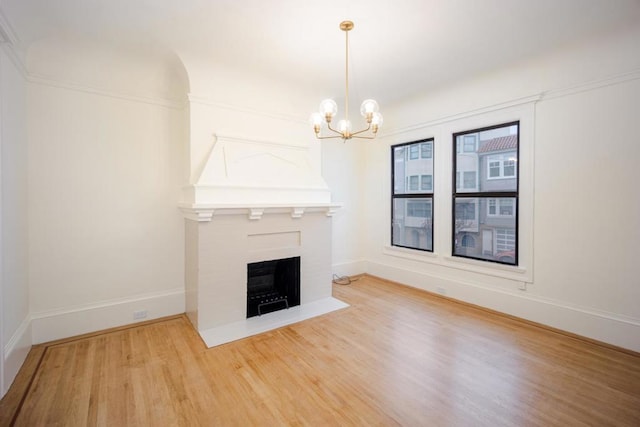 unfurnished living room with a notable chandelier and hardwood / wood-style flooring