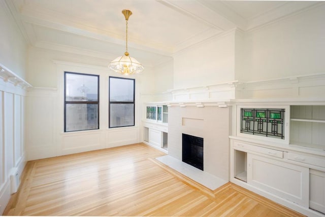 unfurnished living room featuring beam ceiling, ornamental molding, an inviting chandelier, and light hardwood / wood-style flooring