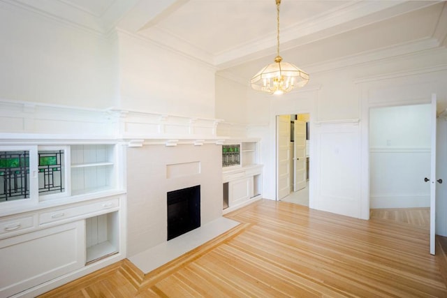 unfurnished living room featuring ornamental molding, an inviting chandelier, built in features, and light hardwood / wood-style floors