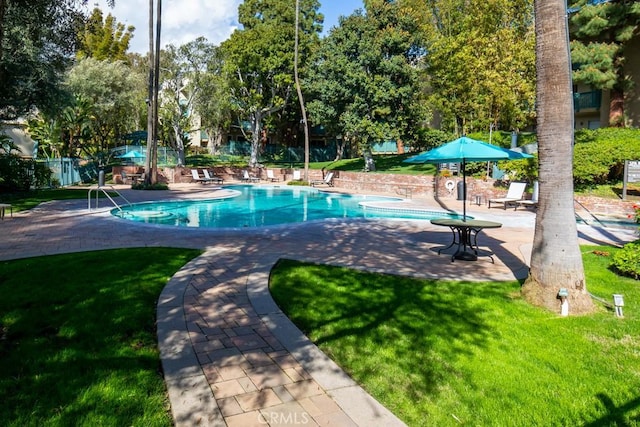 view of swimming pool featuring a patio area and a lawn