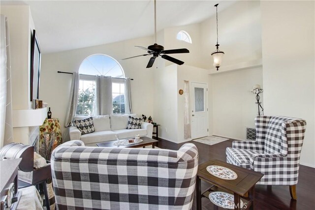 living room featuring dark wood-type flooring, ceiling fan, and high vaulted ceiling