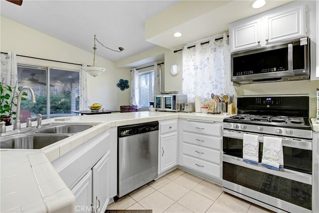 kitchen with white cabinetry, sink, tile countertops, and appliances with stainless steel finishes