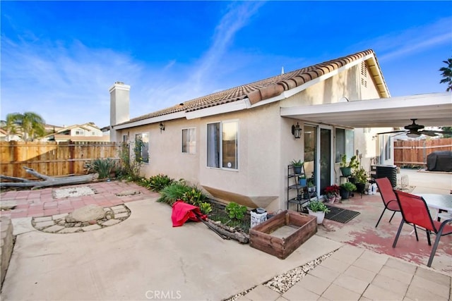 back of house with ceiling fan and a patio area