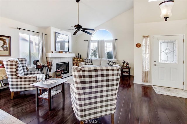 living room with vaulted ceiling, ceiling fan, a fireplace, and dark hardwood / wood-style flooring