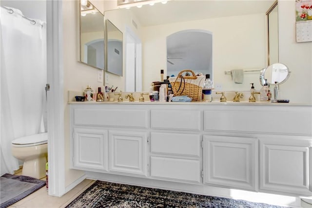 bathroom featuring ceiling fan, tile patterned flooring, a shower with shower curtain, vanity, and toilet