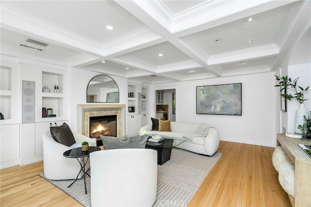 living room with beam ceiling, coffered ceiling, a high end fireplace, and built in shelves