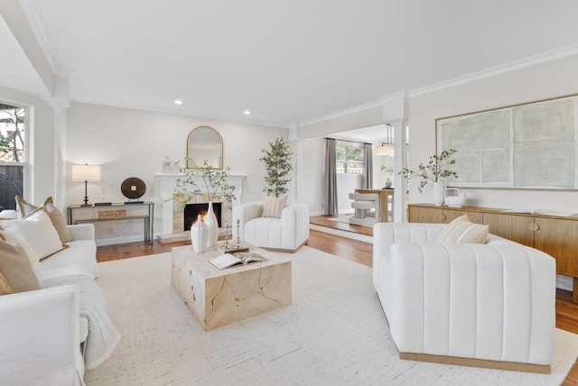 living room featuring ornamental molding, a healthy amount of sunlight, and light hardwood / wood-style flooring