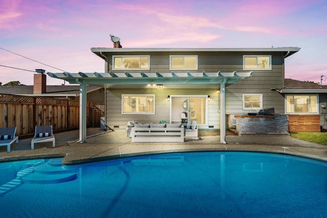 back house at dusk with a fenced in pool, a patio, an outdoor kitchen, and an outdoor bar