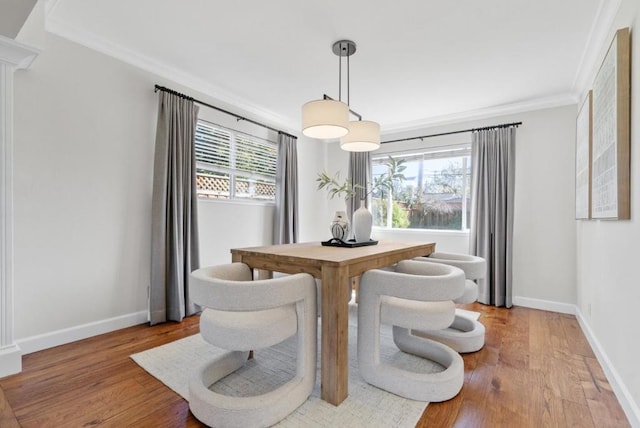 dining space with hardwood / wood-style flooring, crown molding, and plenty of natural light