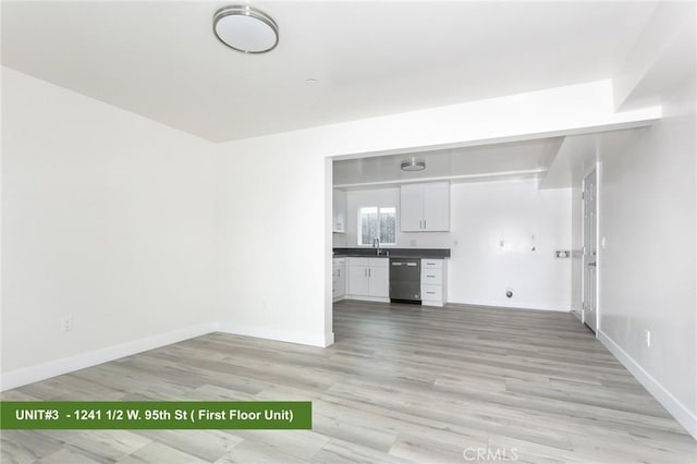 unfurnished living room featuring sink and light wood-type flooring