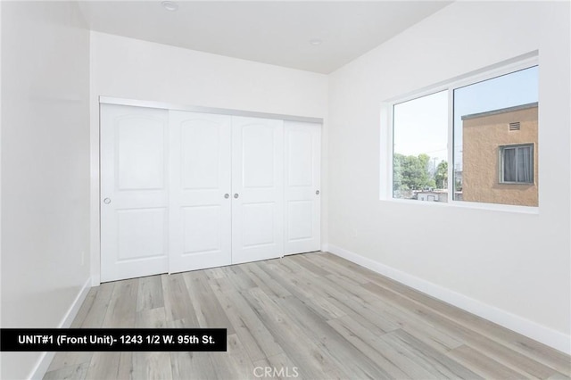 unfurnished bedroom featuring a closet and light wood-type flooring