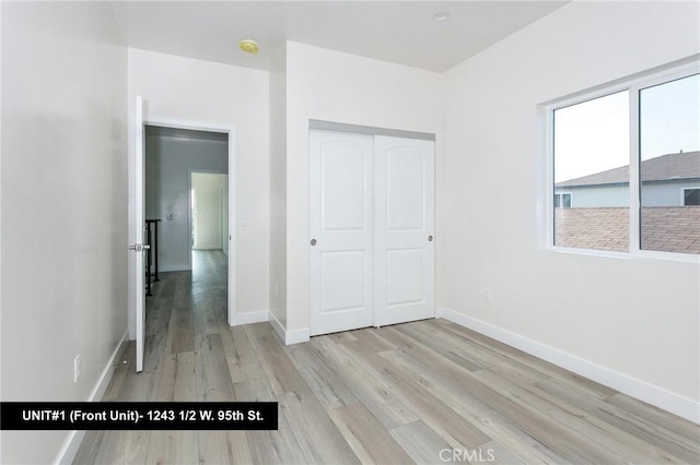 unfurnished bedroom with light hardwood / wood-style floors and a closet