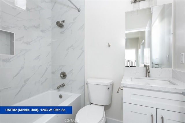 full bathroom with tiled shower / bath, vanity, and toilet