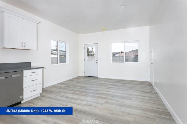 kitchen with light hardwood / wood-style flooring, white cabinets, plenty of natural light, and dishwasher