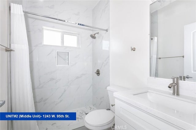 bathroom with vanity, curtained shower, and toilet