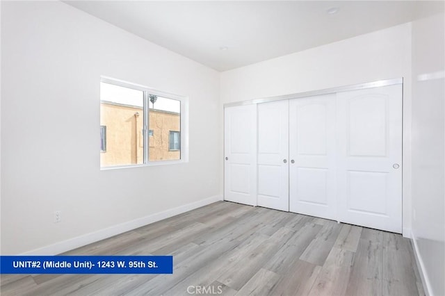 unfurnished bedroom with a closet and light hardwood / wood-style flooring