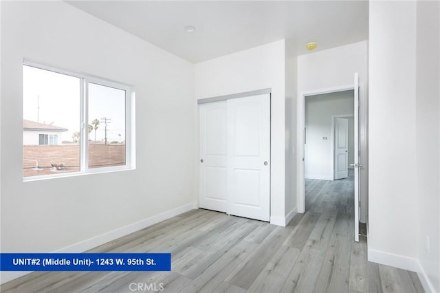 unfurnished bedroom featuring a closet and light wood-type flooring