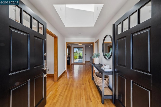 entryway with a skylight and light wood-type flooring