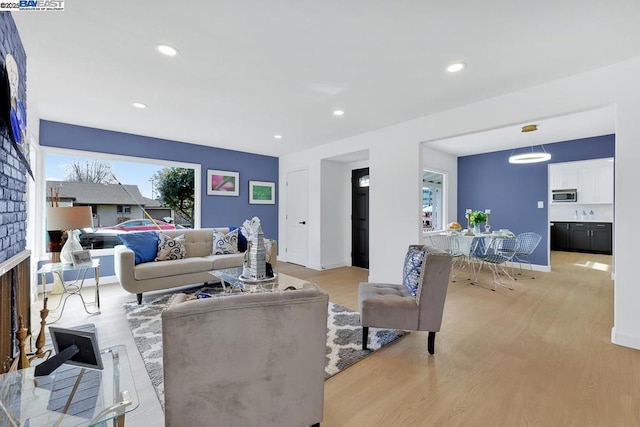 living room with a fireplace and light wood-type flooring