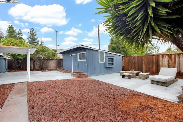 rear view of house featuring a patio, an outdoor structure, and an outdoor hangout area