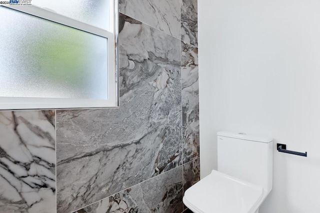 bathroom featuring a shower and toilet