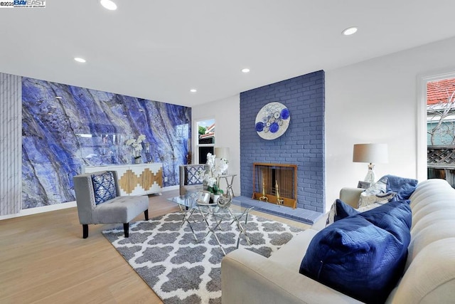 living room with a brick fireplace and hardwood / wood-style flooring