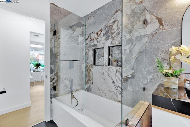 bathroom with wood-type flooring and shower / bath combination with glass door