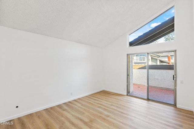 empty room with lofted ceiling and light hardwood / wood-style flooring