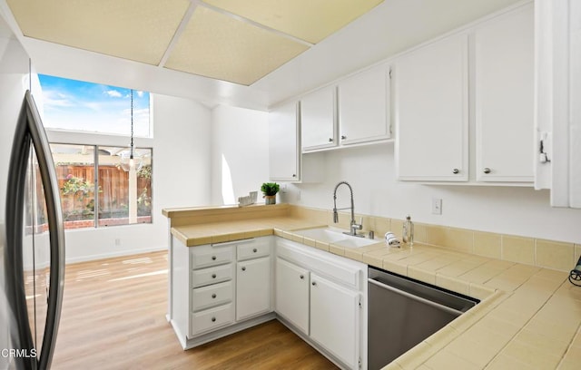 kitchen featuring white cabinetry, sink, tile counters, and stainless steel appliances