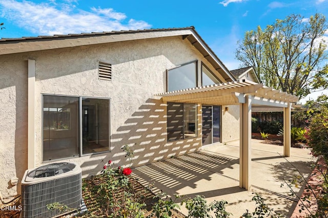 rear view of house with a patio, cooling unit, and a pergola