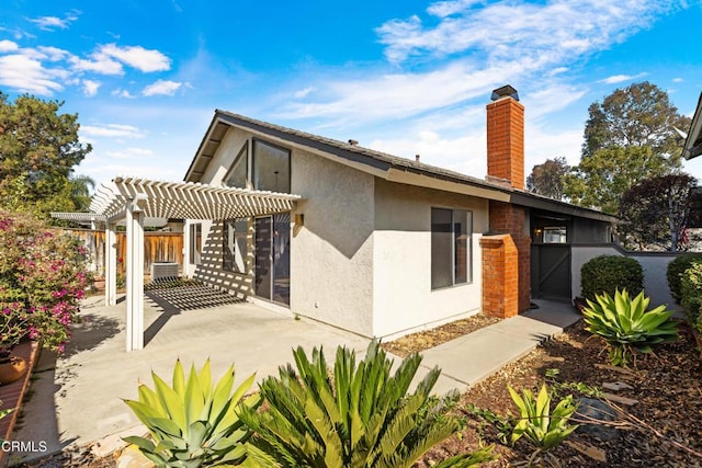 back of property featuring a pergola and a patio