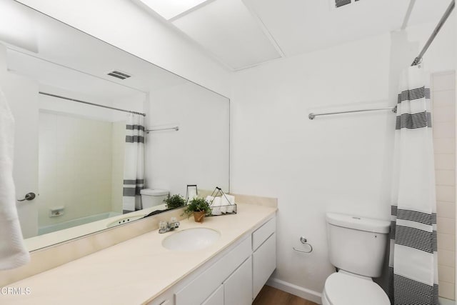 bathroom with vanity, heating unit, and toilet