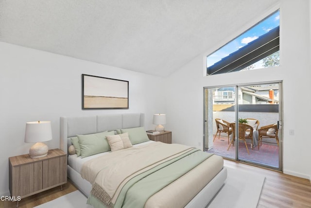 bedroom with vaulted ceiling, hardwood / wood-style floors, and access to outside