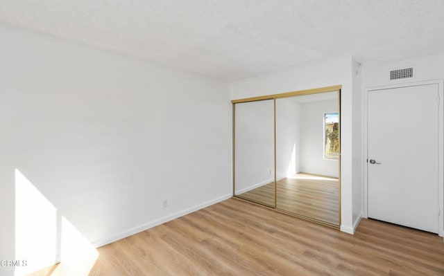 unfurnished bedroom with a closet and light hardwood / wood-style flooring