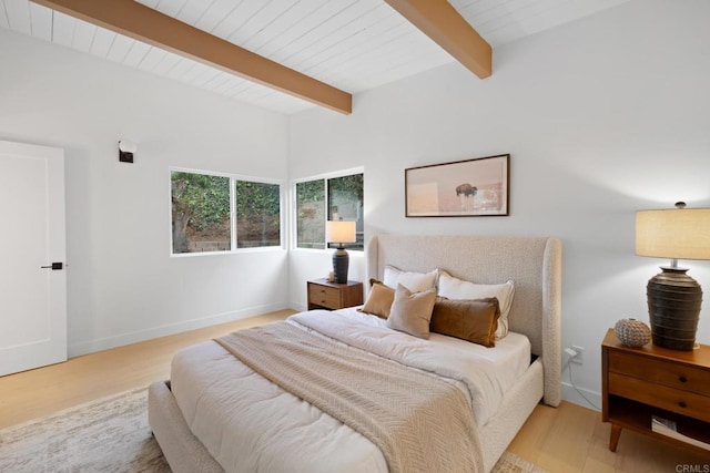 bedroom with beam ceiling and light hardwood / wood-style floors